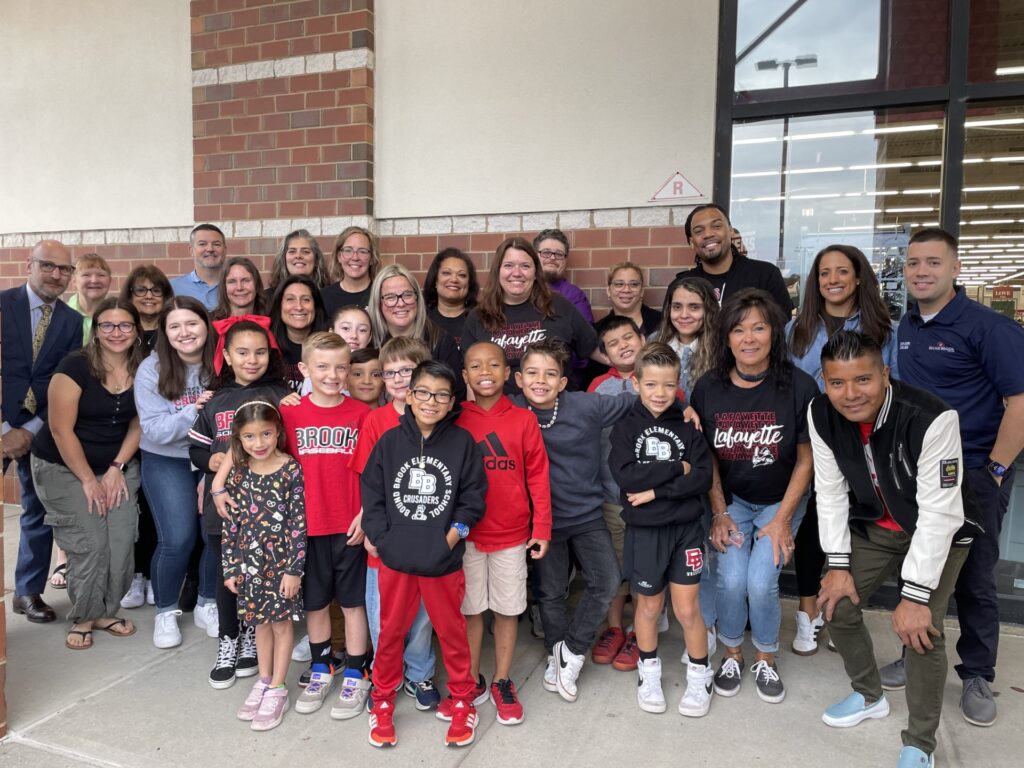 Teachers and students (along with their parents) pose for a photo at the grand opening of the new Burlington store in Bridgewater, minutes before the teachers and students learned about the donation.